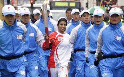 note the second Chinese policeman on the left forcing Connie Huq to hold the torch higher - click to read coverage